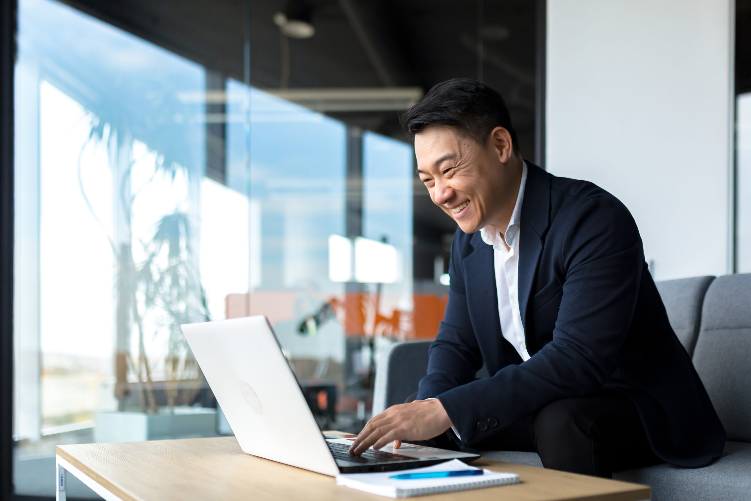 business person looking at their laptop while smiling